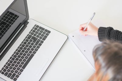 LAPTOP EN IEMAND DIE SCHRIJFT