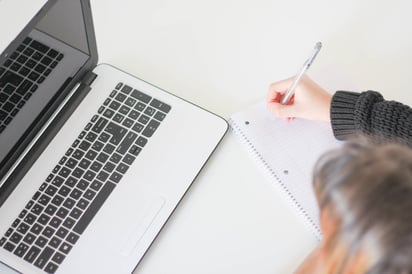 LAPTOP EN IEMAND DIE SCHRIJFT